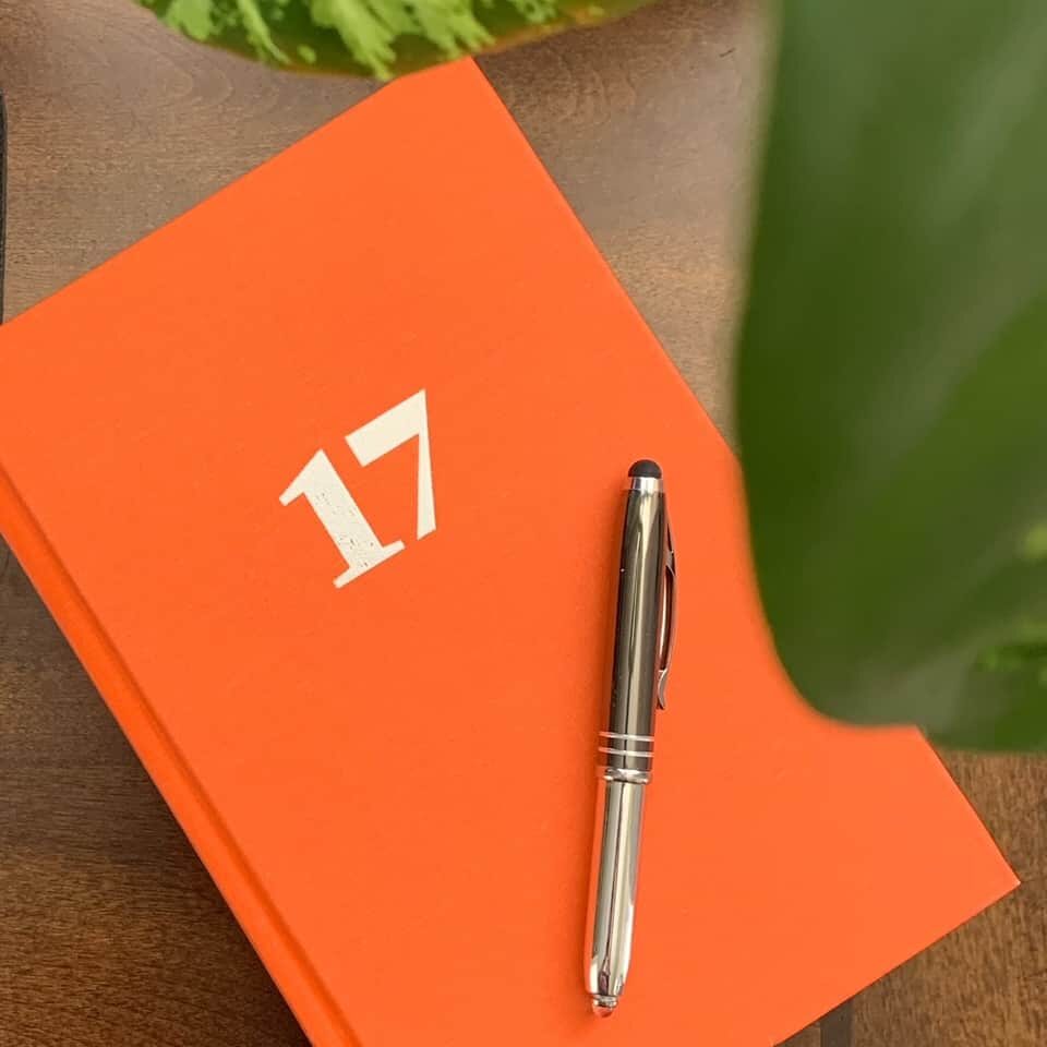 The orange cover of the Chicago Manual of Style, Seventeenth Edition, with a silver pen resting on top.