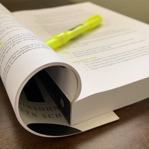 "The Copyeditor's Handbook" is folded open. A yellow highlighter rests on the open page.
